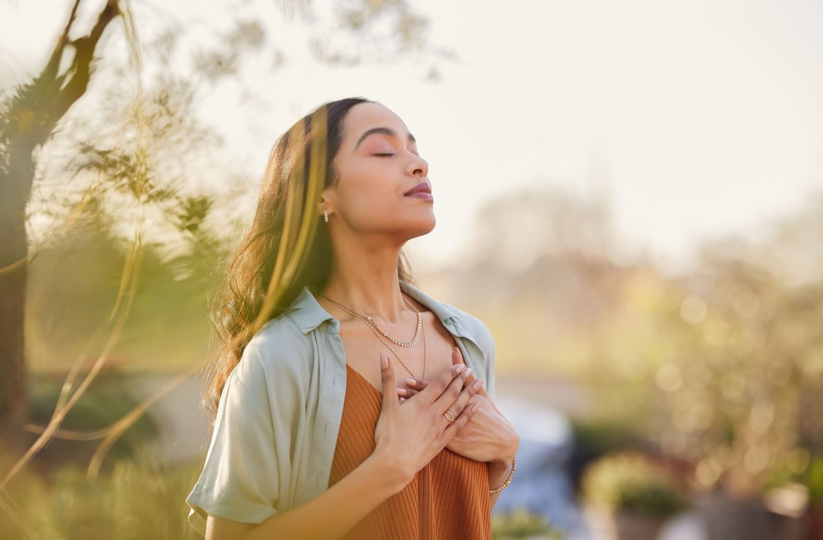 A person standing outside takes in a deep breath of fresh air.