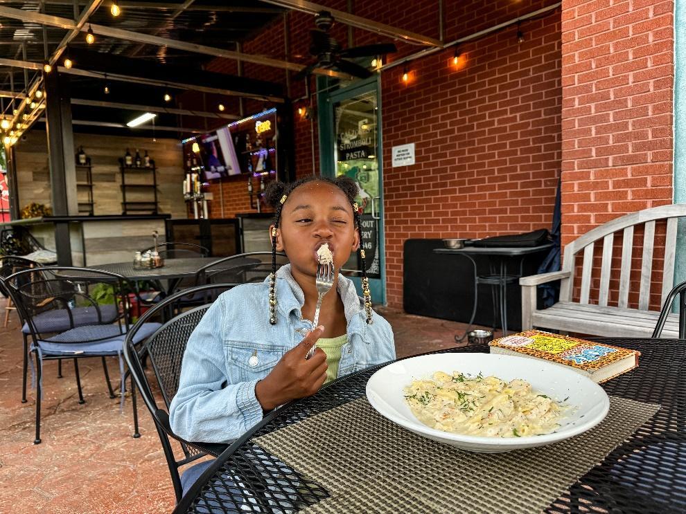 A child eating pasta at a table

Description automatically generated