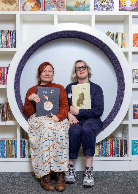 Two women sitting in a round chair

Description automatically generated