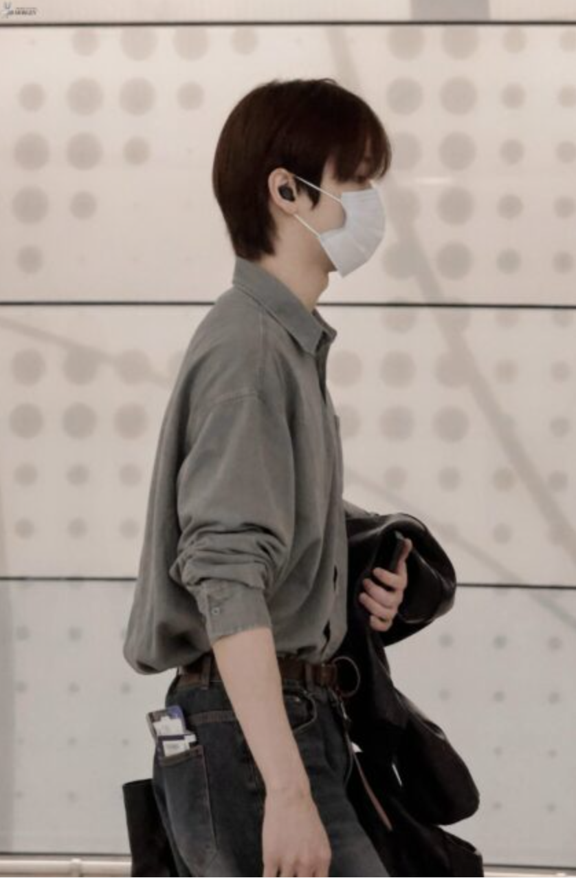 A picture of  RIIZE Seunghan wearing face masks and holding a black jacket on  his hand 
