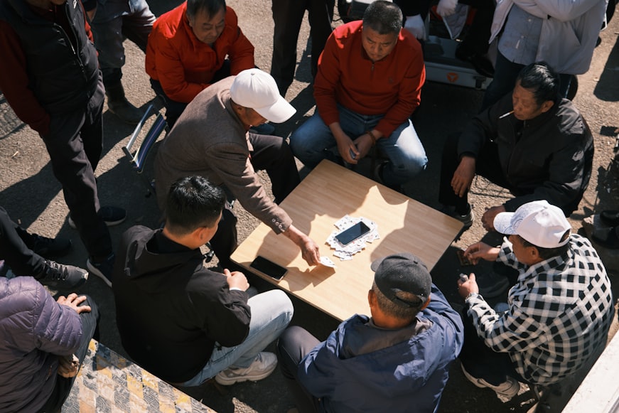 People play a game around a table.
