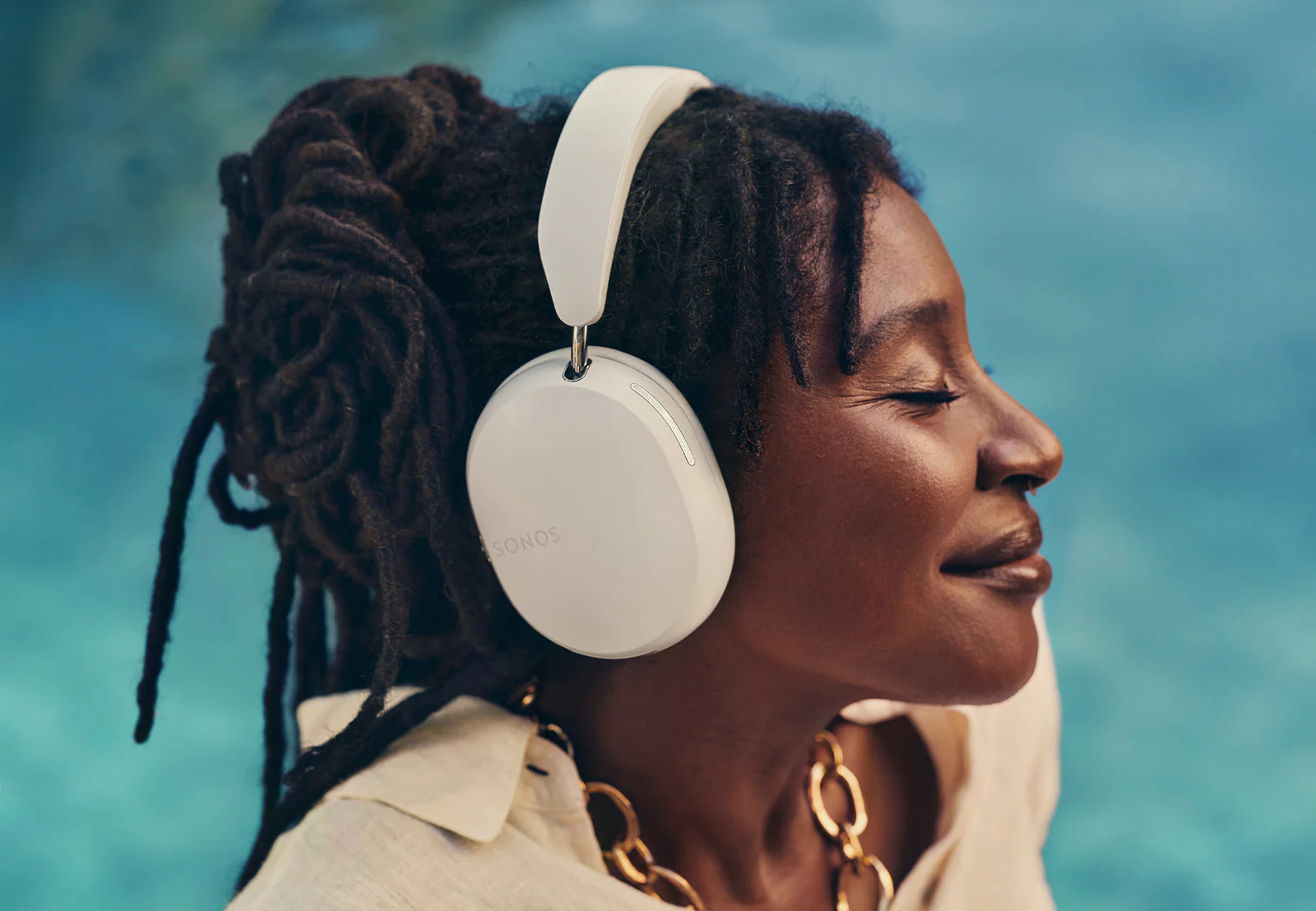 Woman wearing Sonos Ace headphones in white color.