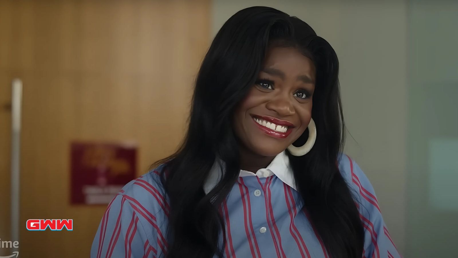 Shoniqua with long black hair in a striped blue shirt.