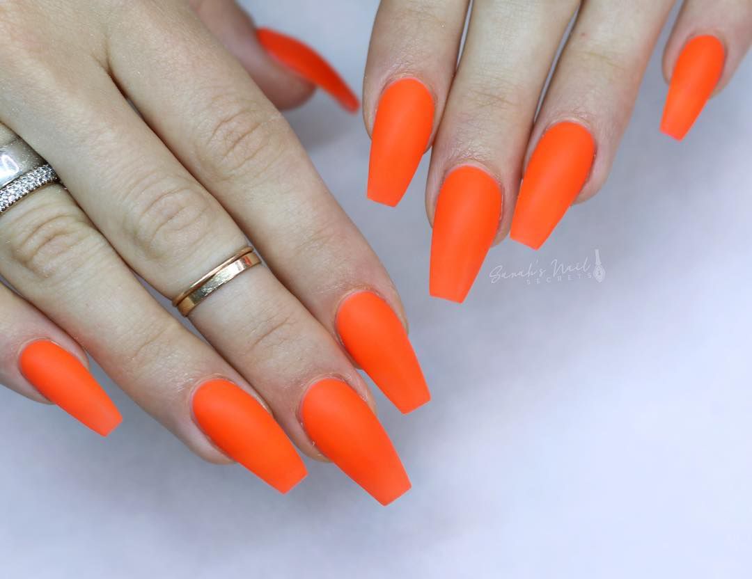 Close up of nails with glittery orange nails having Matte Orange Perfection