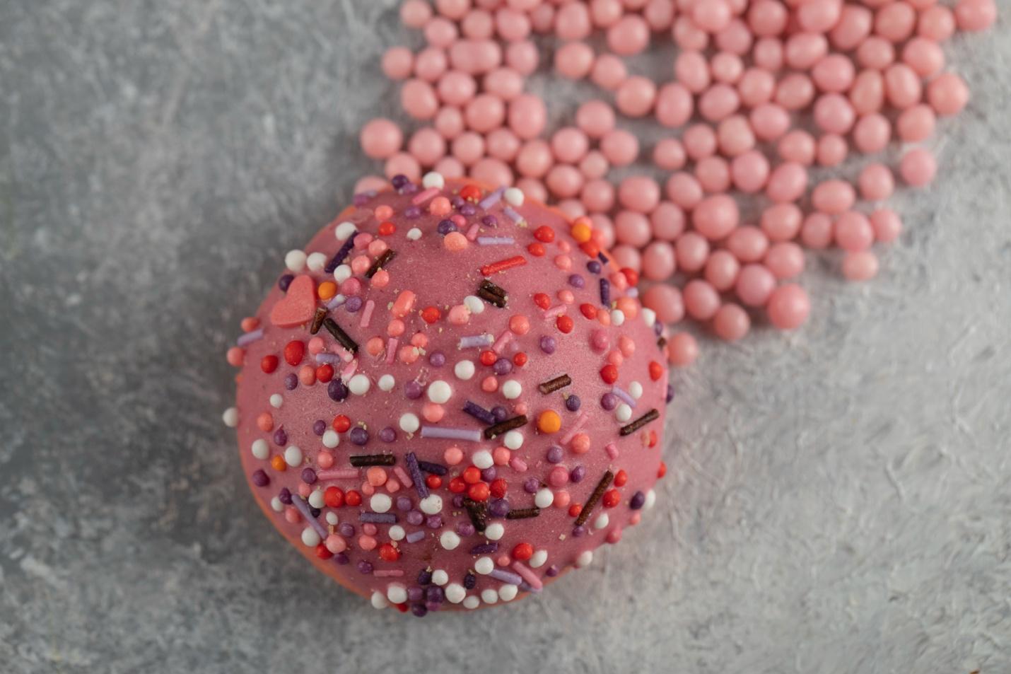 A pink doughnut with sprinkles on top

AI-generated content may be incorrect.