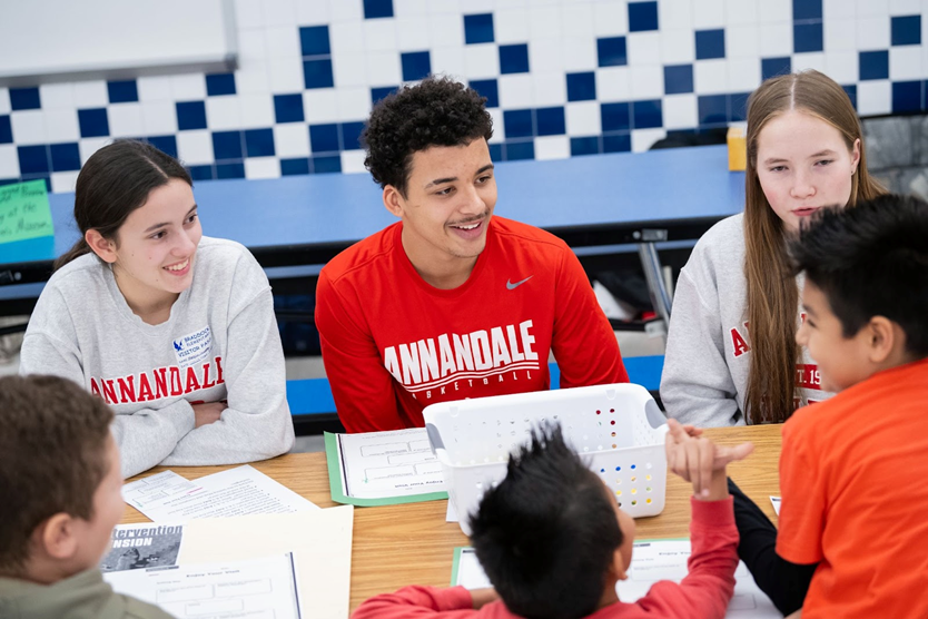 High school students from Annandale High School talk with Braddock Road third graders about reading. 