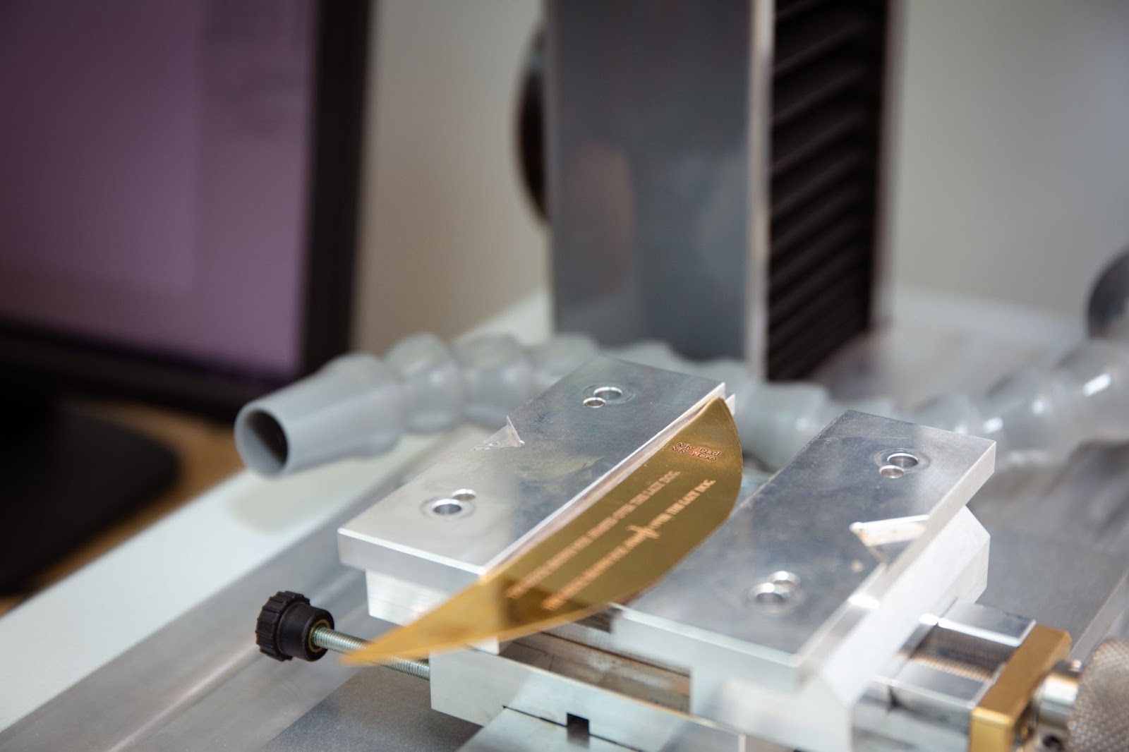 Gold plate being engraved by engraving machine.