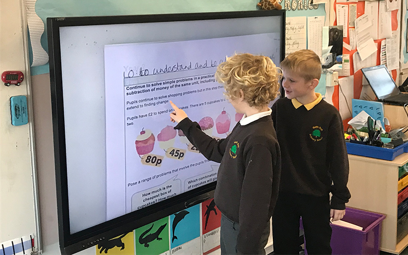 Schoolboys engaging with a touch screen display in the classroom