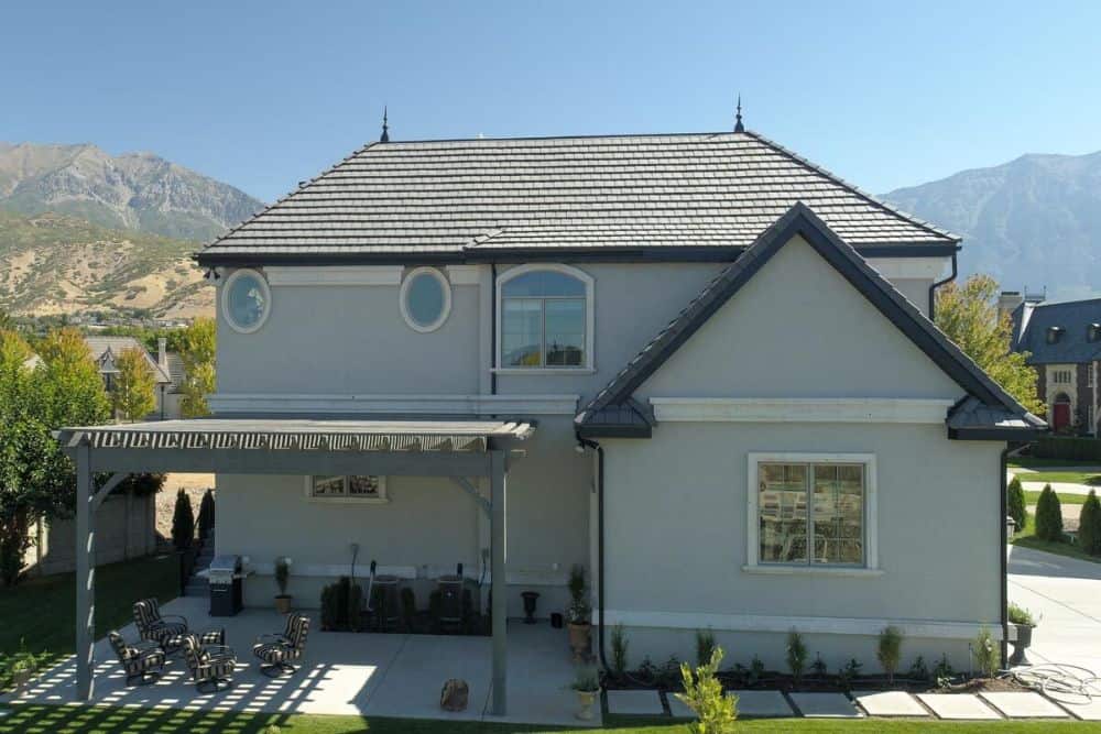 Rear exterior view with hipped and gable rooflines along with an airy patio topped with a trellis roof.