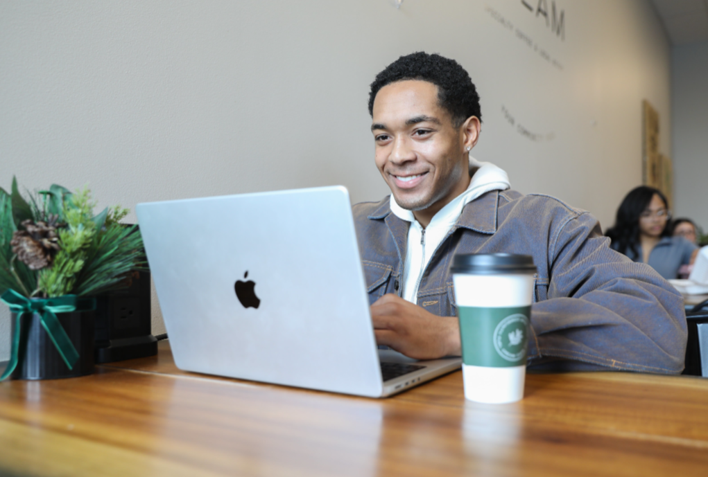 Working professional earning an online MBA in a café, showcasing flexibility and career growth.