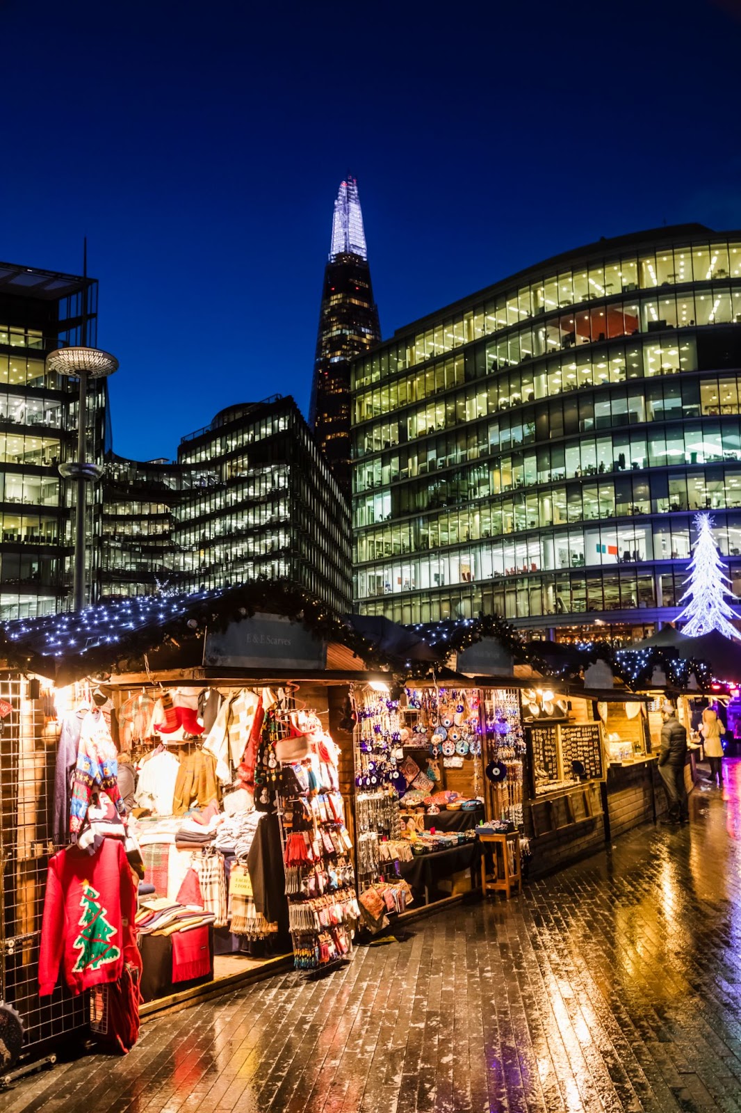 Winter by the River at London Bridge City with festive stalls, twinkling lights, and visitors enjoying seasonal food and drinks with views of the Thames