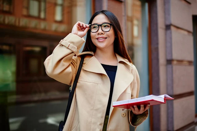 woman with glasses wearing stylish work wear smiling and happy