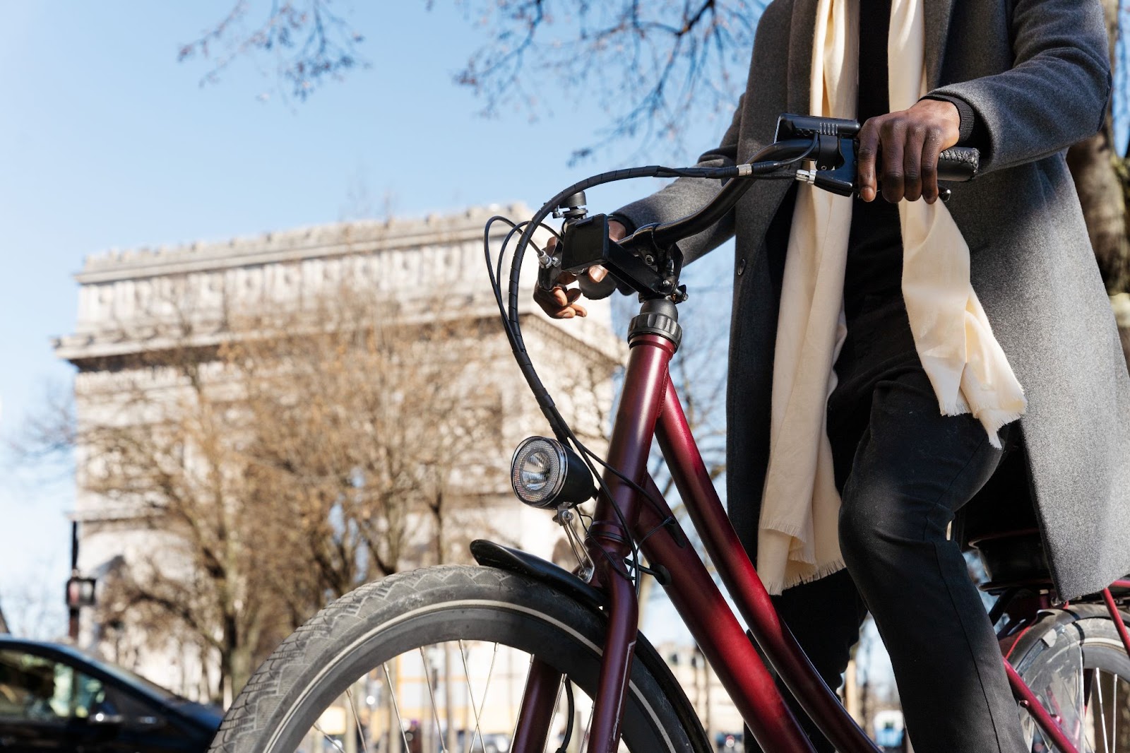 A man at the foot of the Arc de Triomphe with a OneBike rental bike