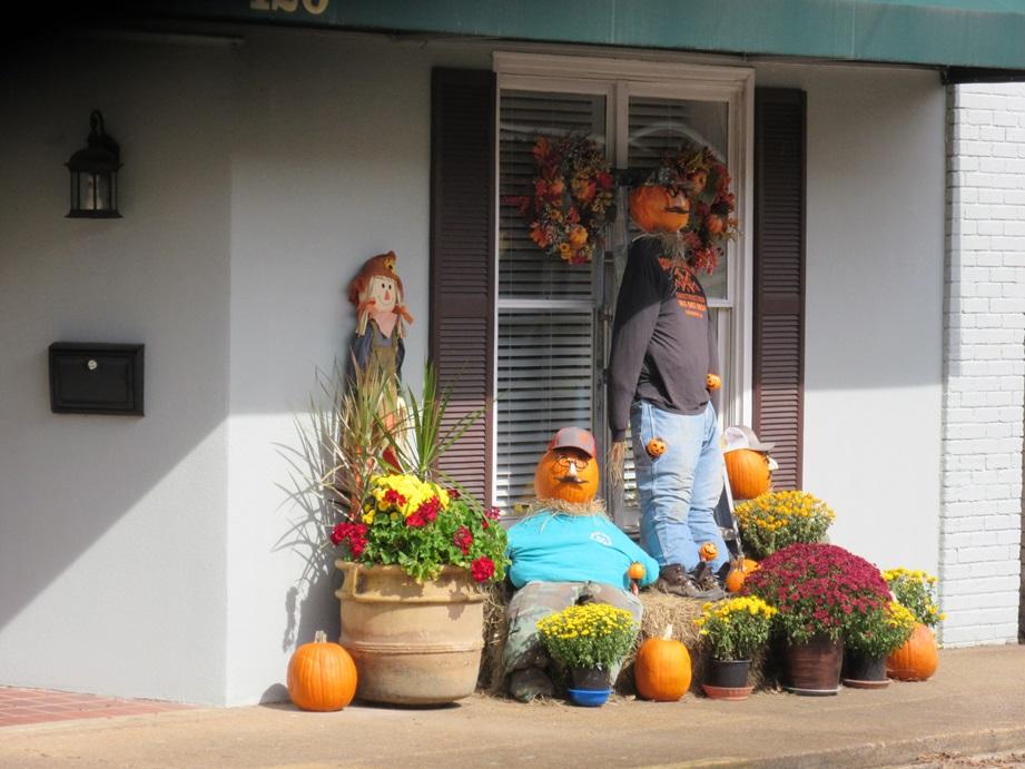 A person standing next to a couple of pumpkins

Description automatically generated