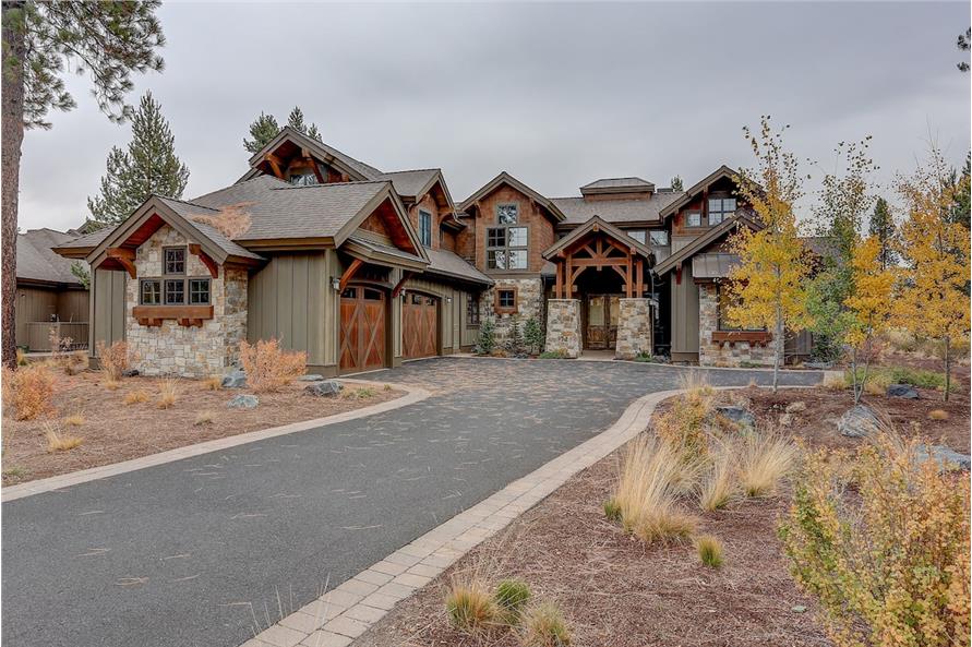 A concrete driveway leads to the entry porch and side-entry garage.