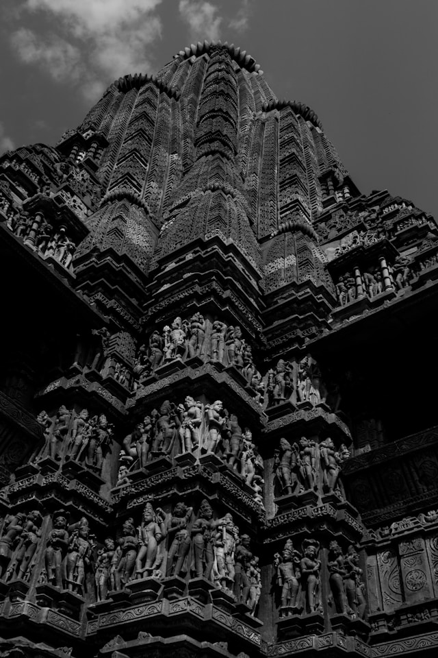 Intricately carved stone temple facade, showcasing detailed sculptures and ornate designs, reflecting traditional Indian architecture.