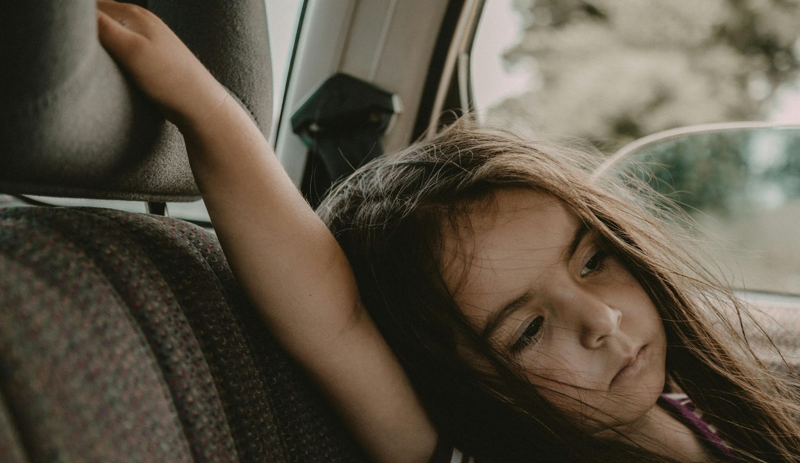 A Young Girl Sitting Inside the Car