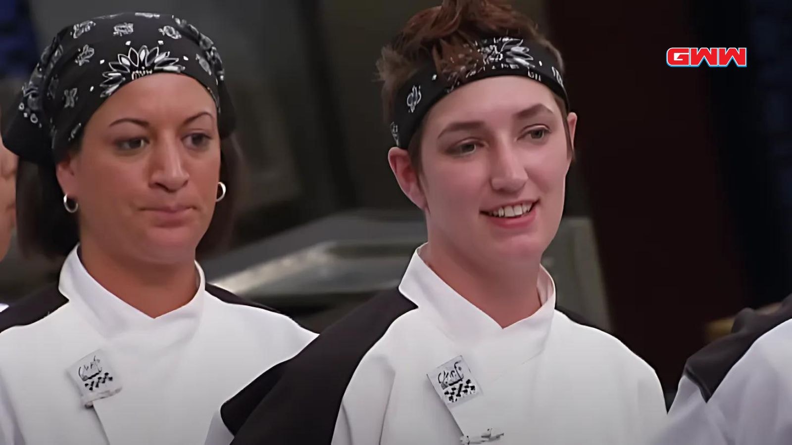 Female contestants in chef uniforms smiling during a competition