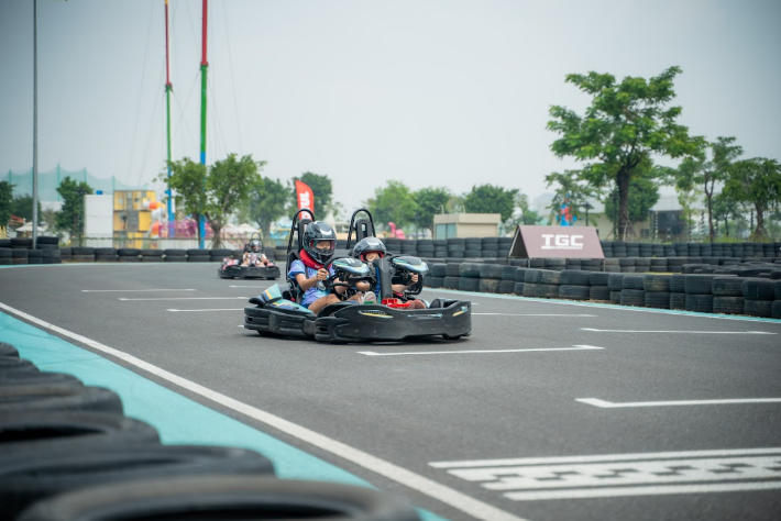 People driving go karts on a trackAI-generated content may be incorrect.