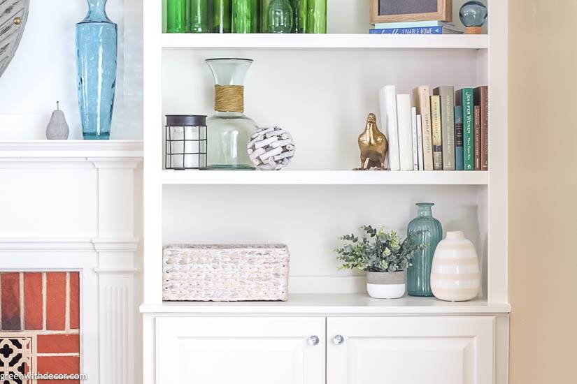 a white shelves with books and vases