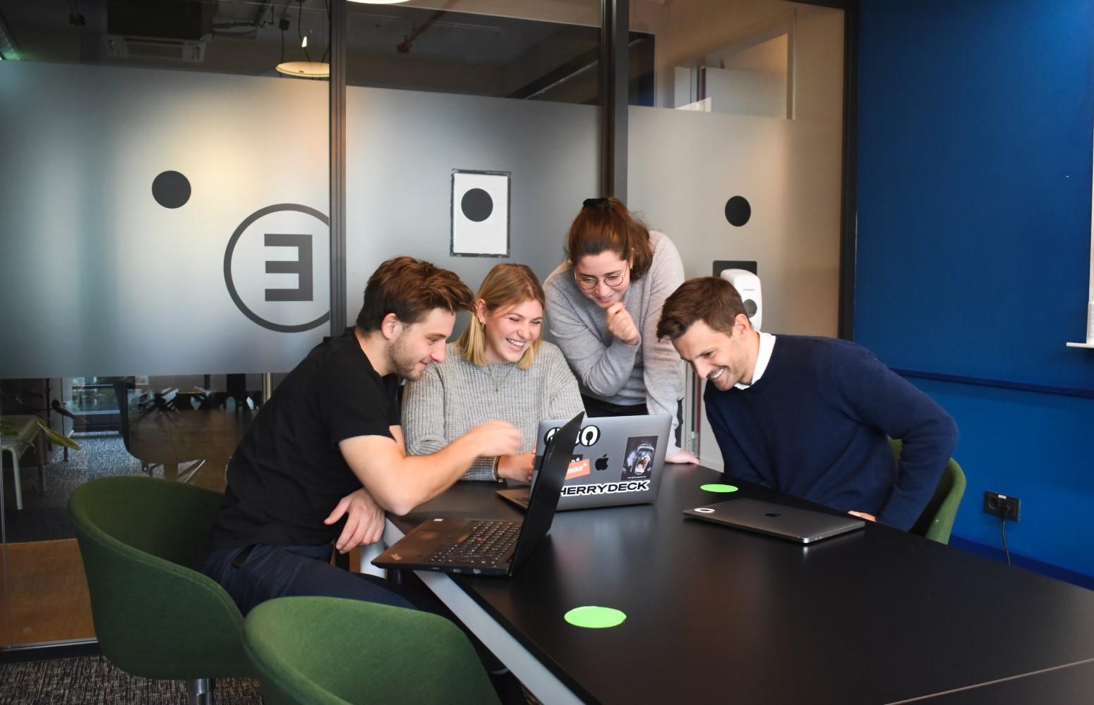 A group of people looking at a computer

Description automatically generated