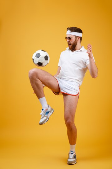 A footballer playing with a football