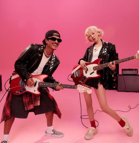 This contain BLACKPINK's Rosé and Bruno Mars' "APT.  are posing with guitars in front of a pink background