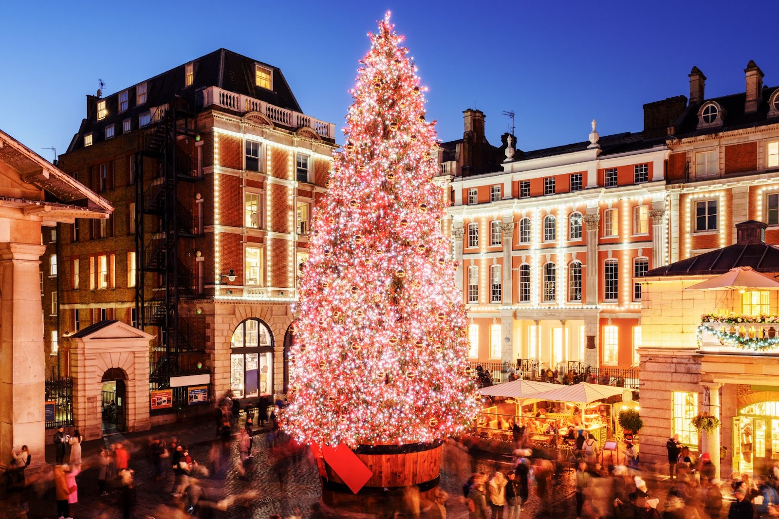 Covent Garden Christmas Market with festive decorations, holiday stalls, and visitors enjoying the seasonal atmosphere in London.