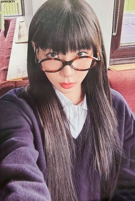 This  contain an image of Taeyeon with glasses on her head and long black hair is looking at the camera