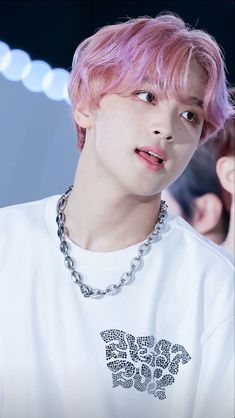 This contains an image of Haechan's with a pink hair wearing a white t - shirt and silver chain around his neck