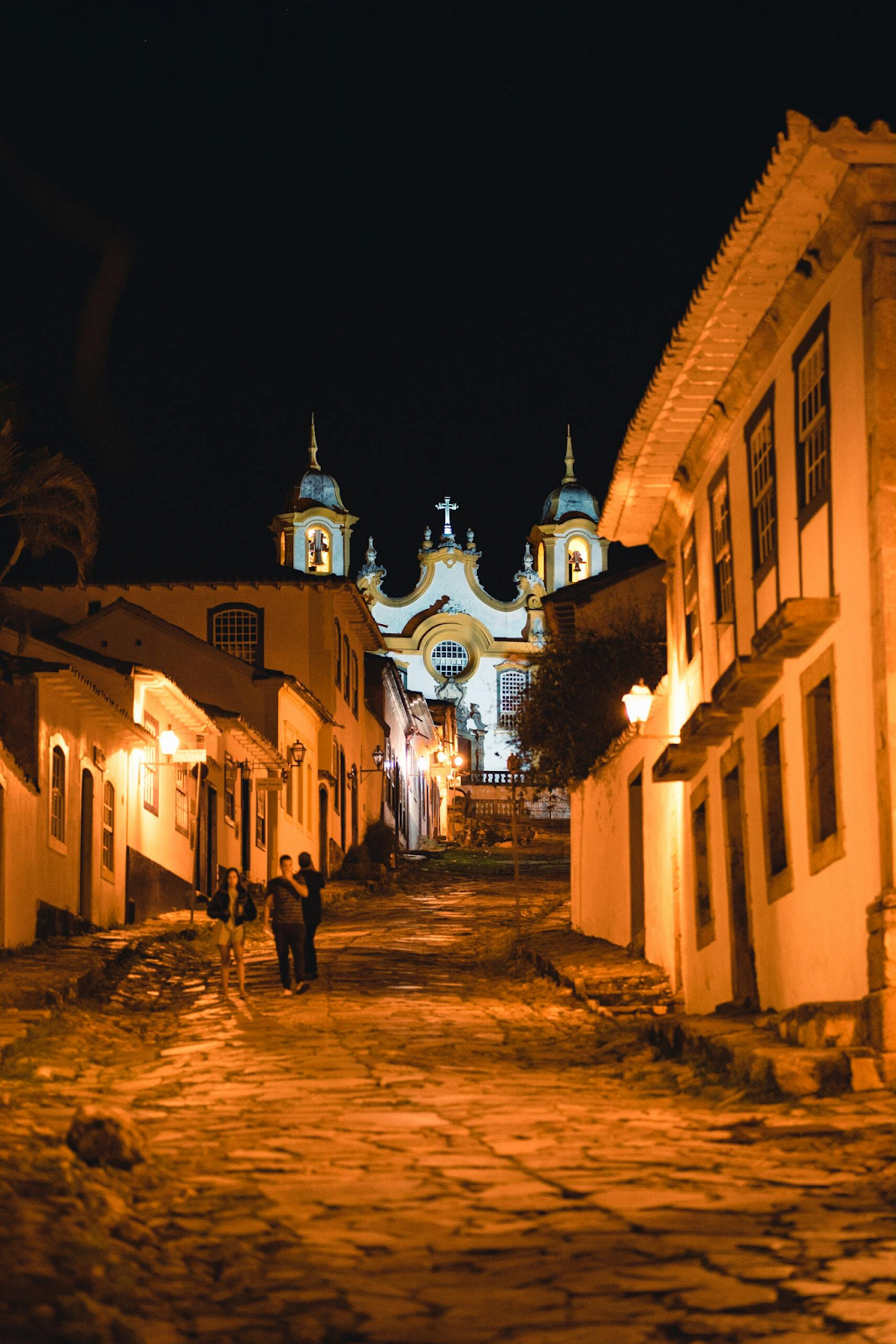 A rua de uma cidade histórica a noite desfocada com uma igreja ao fundo em destaque mostrando um tipo de fotografia