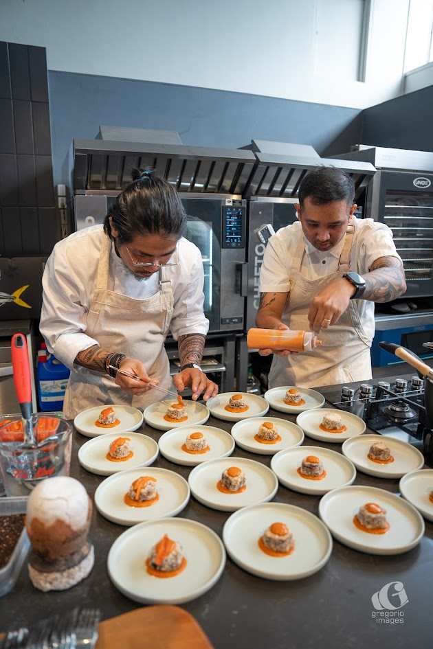 A couple of chefs preparing foodDescription automatically generated