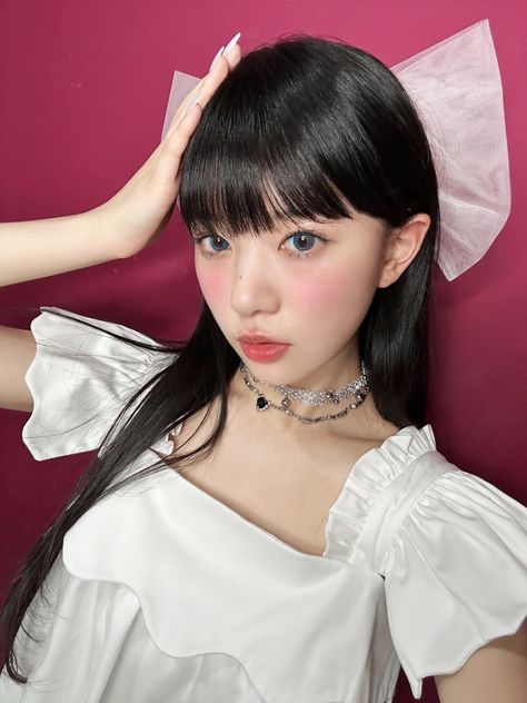 This contain Moka with black hair wearing a white dress