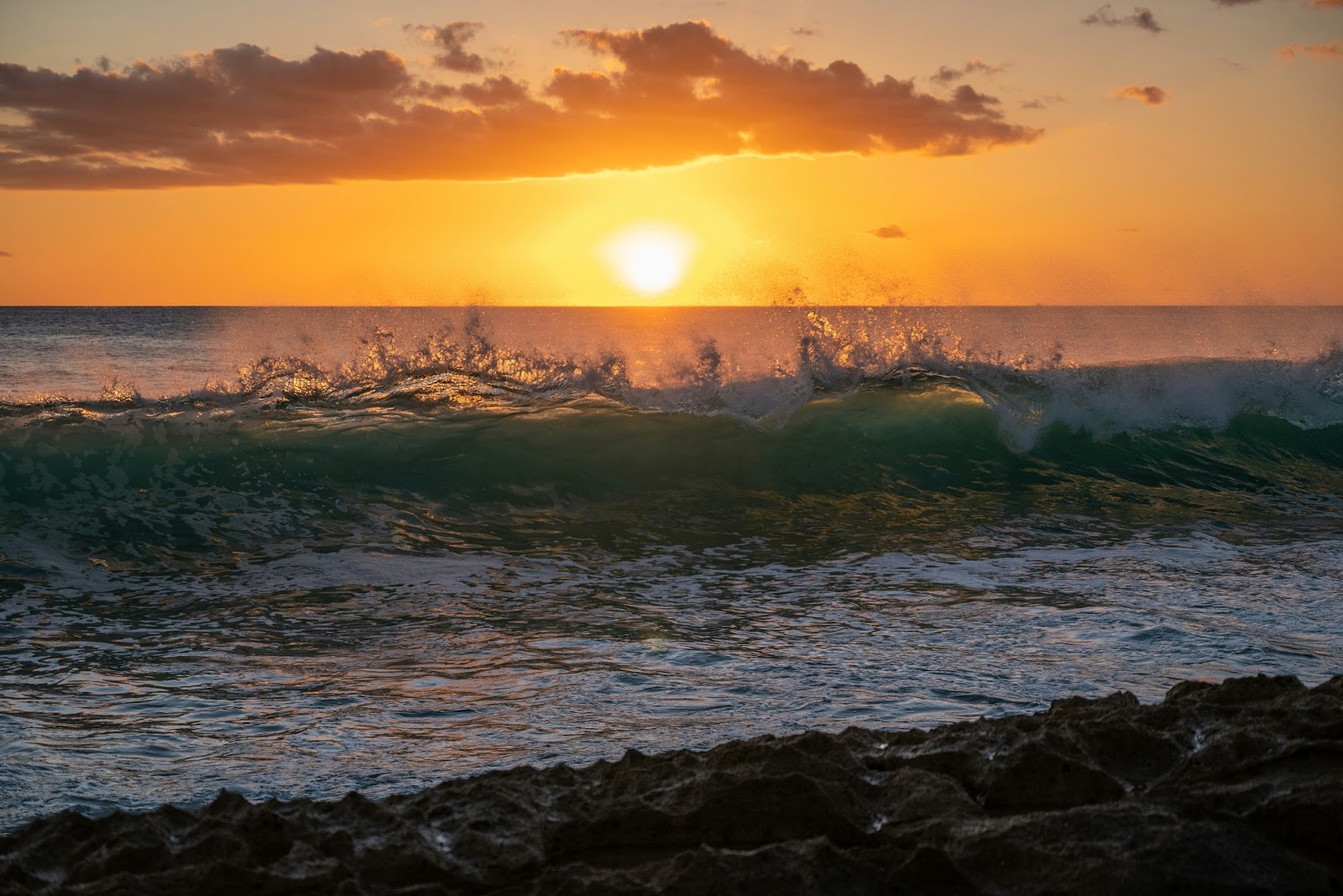 A sunset over Makaha Beach’s golden sands, perfect for a secluded luxury getaway.