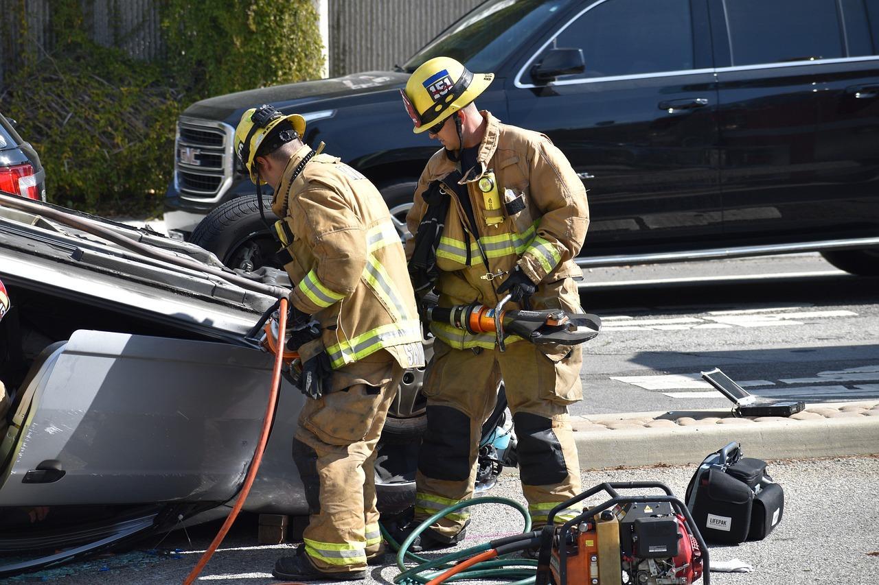 A firemen in uniform looking at a car

AI-generated content may be incorrect.