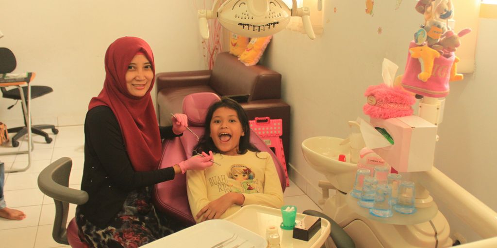 woman in black long sleeve shirt sitting beside girl in pink shirt