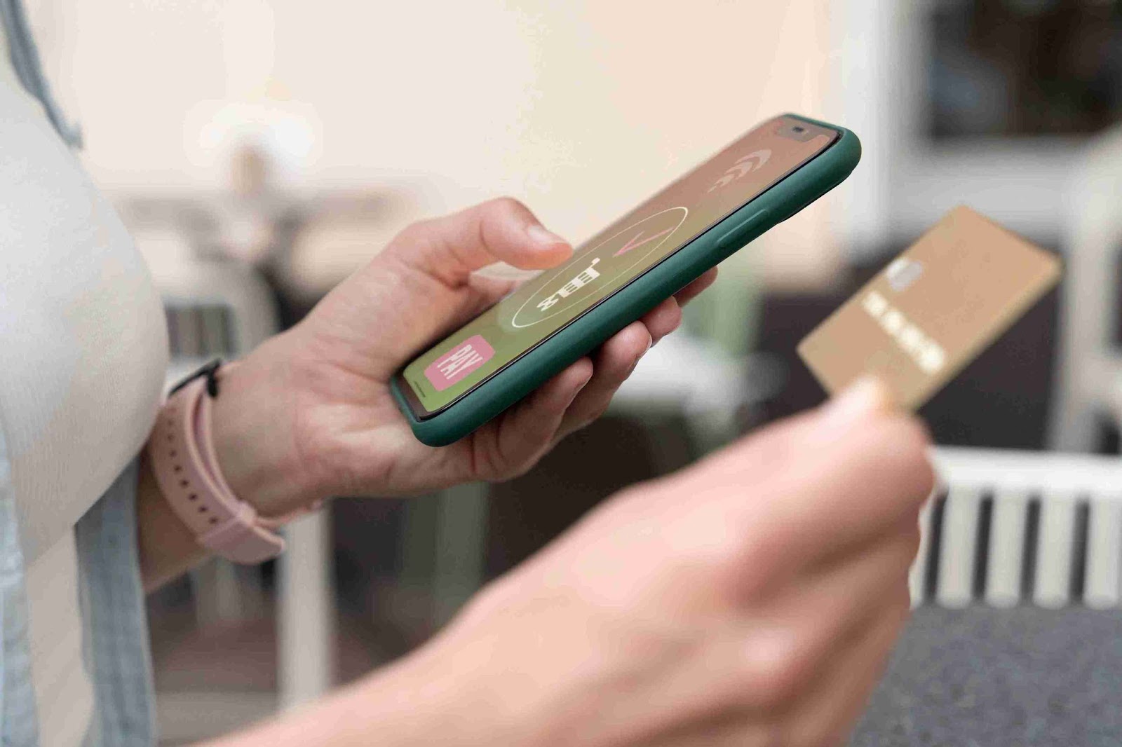 Hand holding a smartphone and gold credit card, possibly engaging in mobile deposit transactions