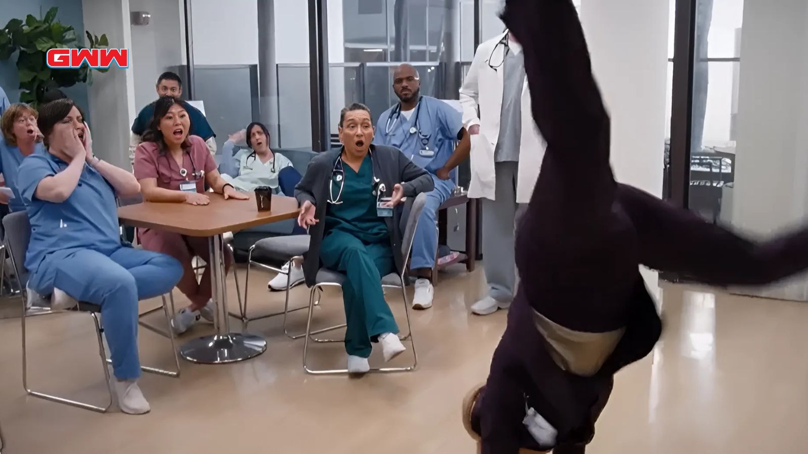 Wendi McLendon-Covey as Joyce doing a cartwheel in front of the medical staff