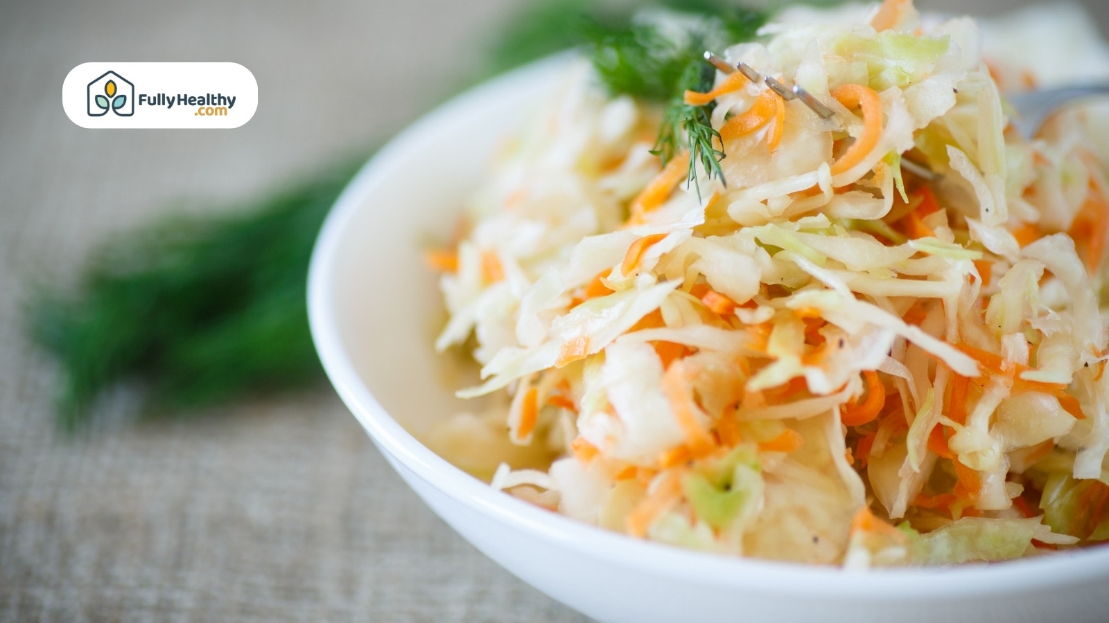Fresh sauerkraut salad in white bowl with dill garnish