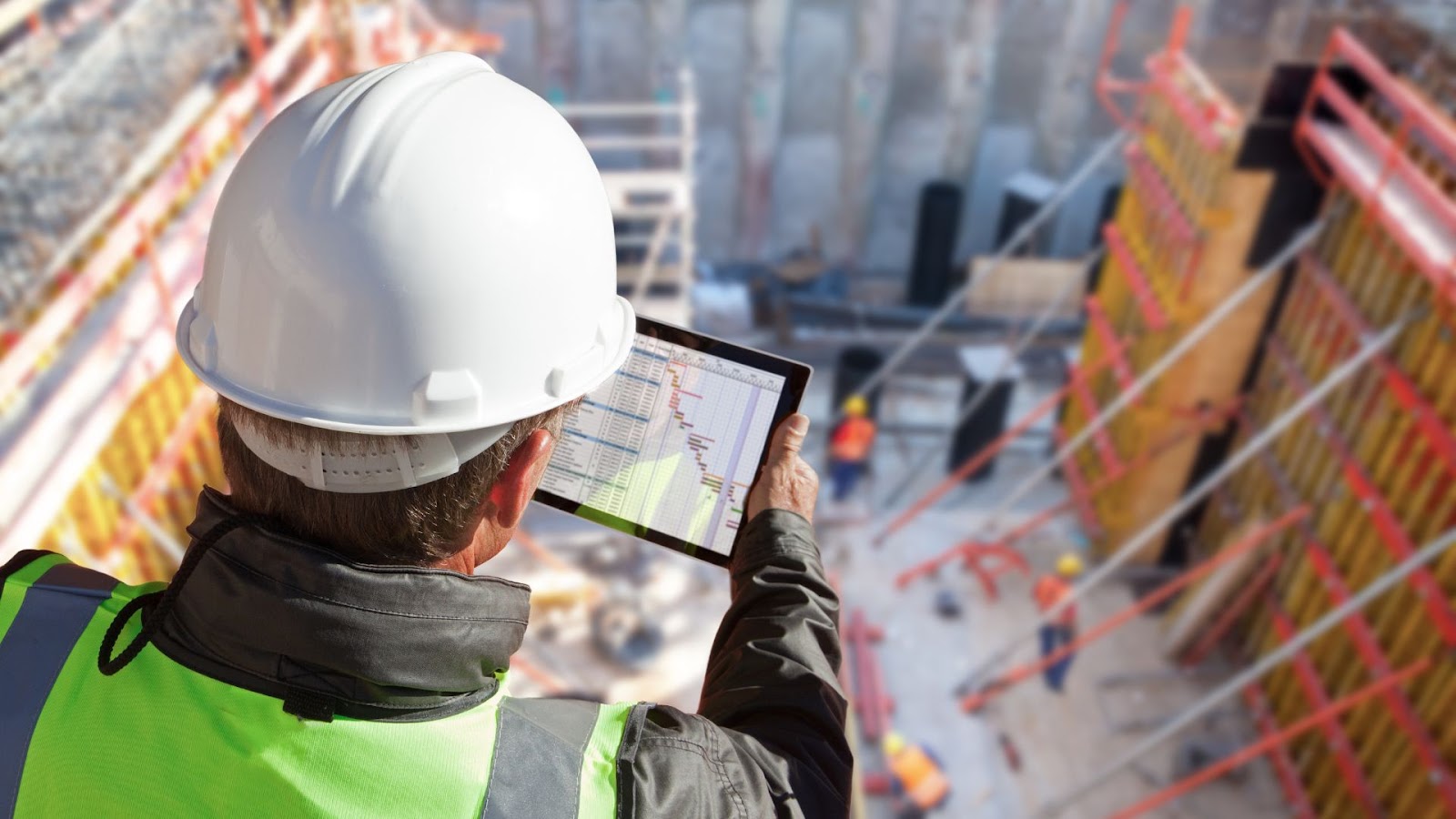 A construction worker using a tablet computer at a construction site.