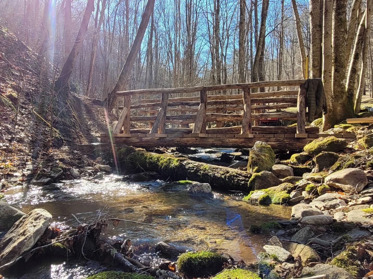 A tranquil stream running under crossing trail bridge at The Retreats at Spring Creek Preserve.