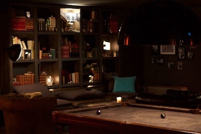 Small pool table in a cool brown room with low lighting.