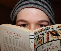 A person with a hat covering their face with a book

Description automatically generated