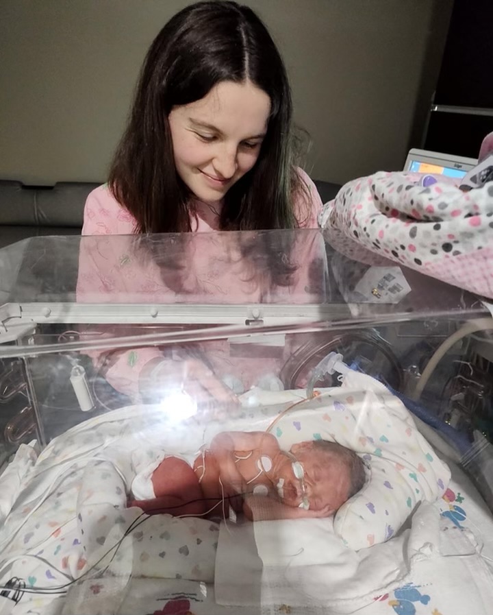 Mom admires her baby in the NICU.