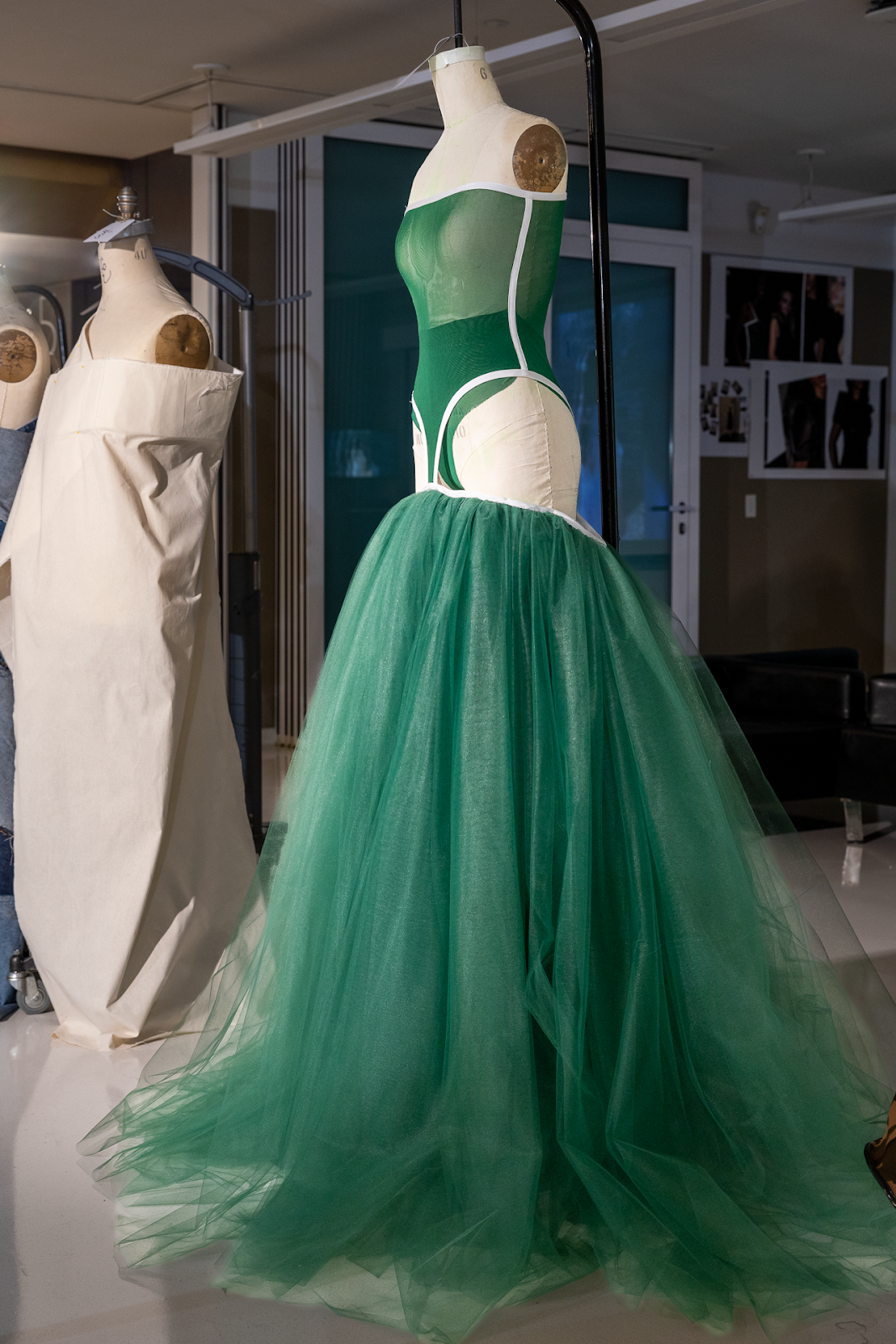 A green dress with a fitted off the shoulder leotard top and puffy dramatic sheer long skirt. 