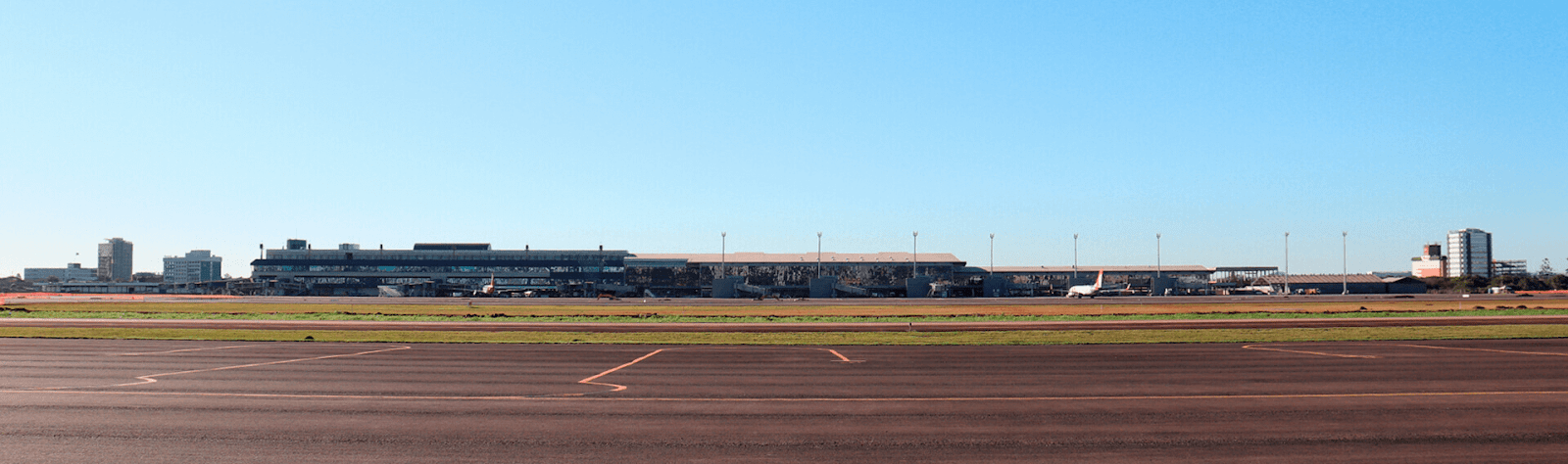 Vista panorâmica do Aeroporto de Porto Alegre, destacando a pista de pouso recém-reformada e o terminal ao fundo, com céu claro e limpo.