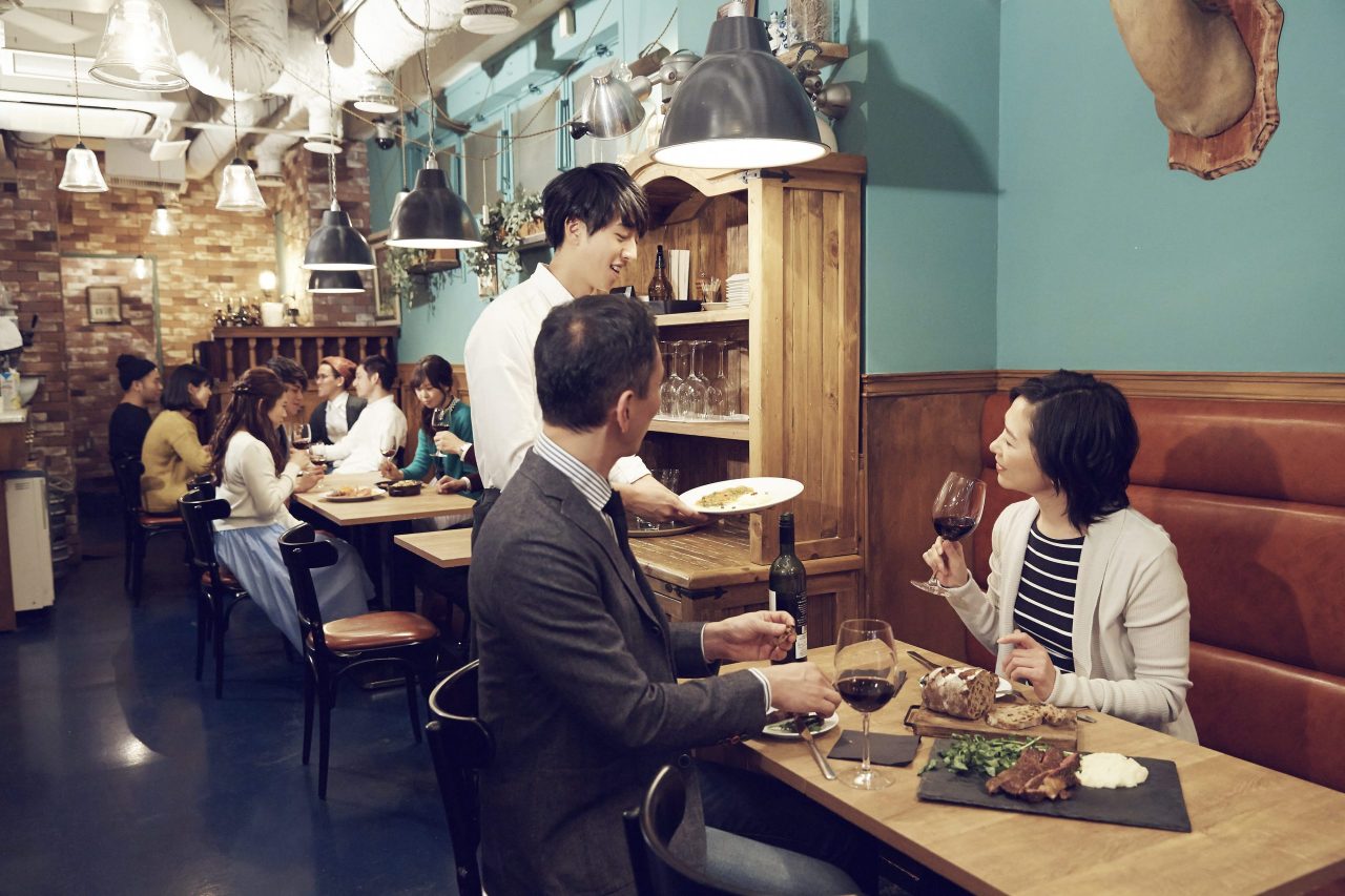 飲食店で店員がお客様に料理を提供している様子