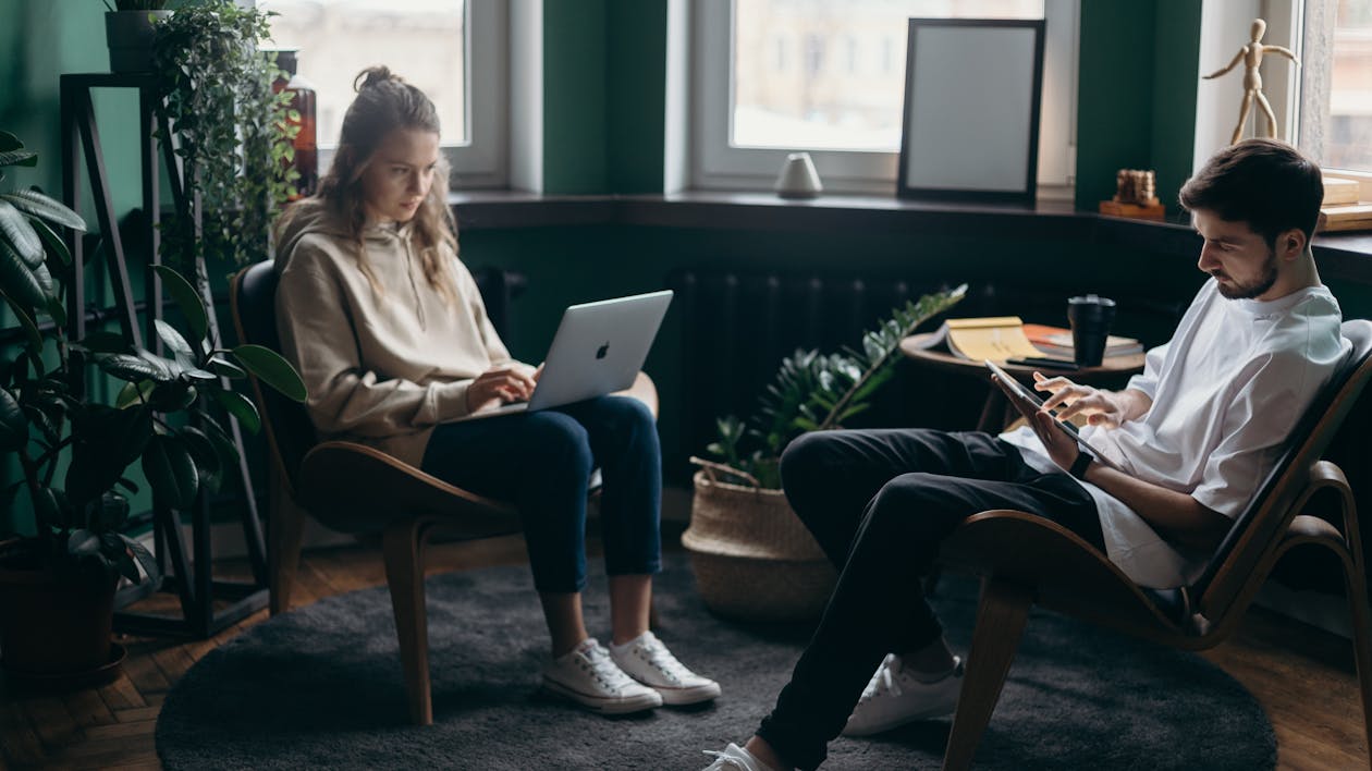 Free A couple working remotely in a stylish home office with plants and modern decor. Stock Photo