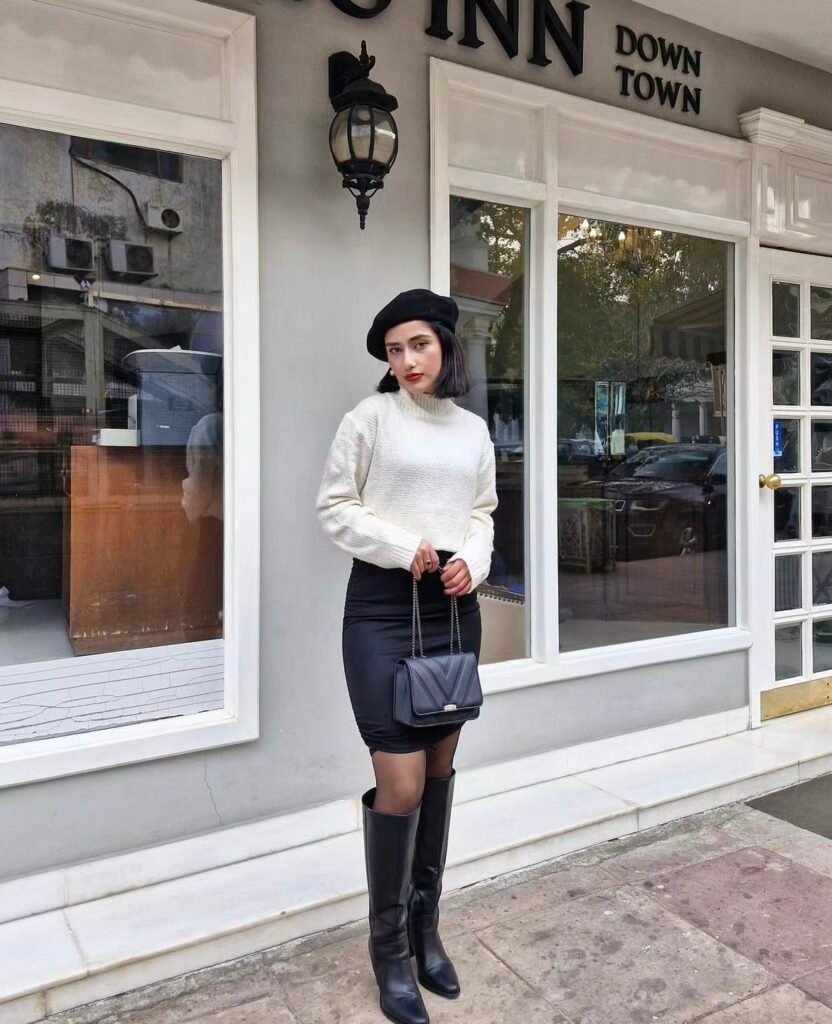 A white sweater, a black skirt and a beret.