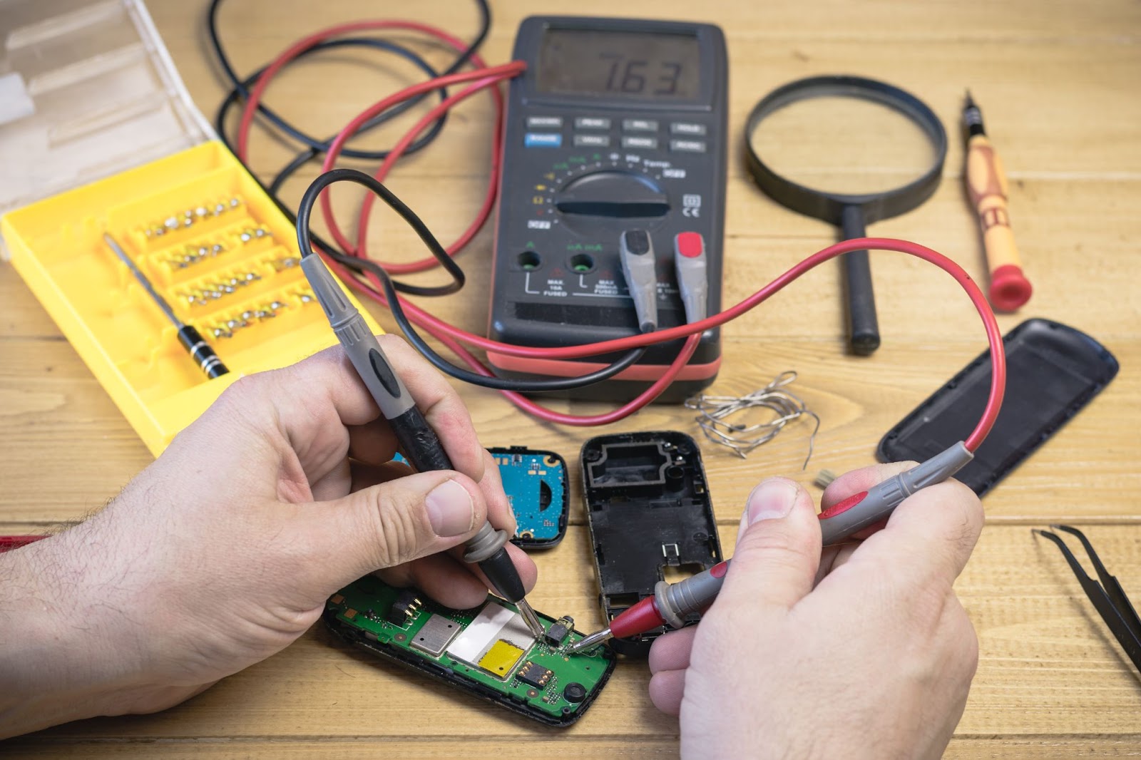 Closeup shot of a digital multimeter being used to test a device.